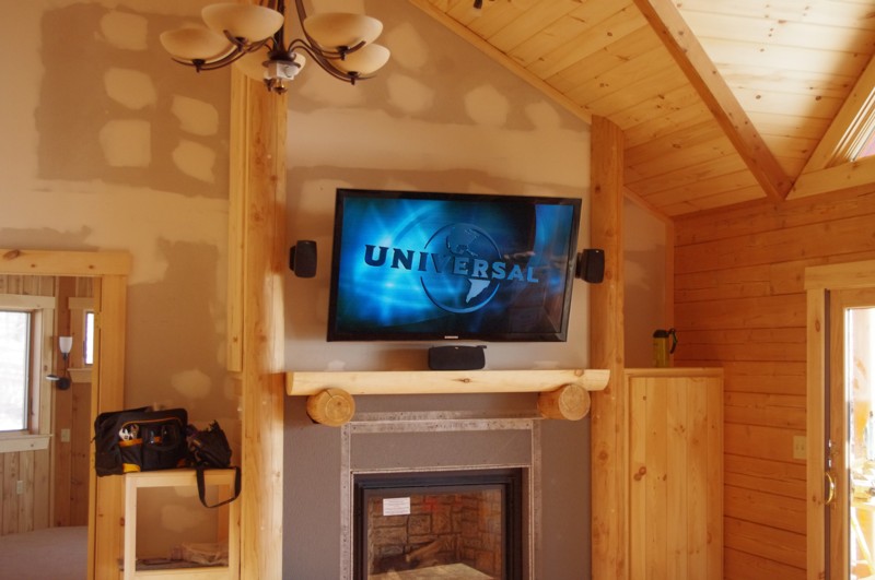 Tv mounted over Fireplace in Loghome